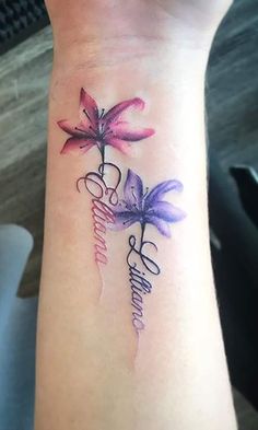 a woman's wrist tattoo with three flowers and the word love on it,