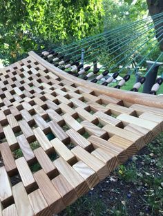 a wooden hammock sitting in the grass