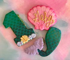 two decorated cookies sitting on top of a table next to each other with the word joy spelled out