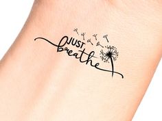 a dandelion tattoo with the words just breathe on it