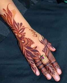 a woman's hand with henna tattoos on it