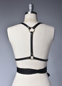 High quality, durable-yet-delicate bespoke harness made in thick PVC or black leather. Fancy, tassel trimmed grosgrain ribbons wrap around the waist and tie into a bow. Fit is adjustable with buckles and straps. The waist is also extremely adjustable due to the ribbon ties. Silver or gold-toned nickel plated steel hardware. Color shown is "Black PVC/Gold Hardware" and "Black Leather/Gold Hardware". Both available with silver tone hardware.All pieces are MADE TO ORDER, standard sizes XS-4XL. If y Adjustable Leather Harness With Belt, Elegant Fitted Black Harness, Gothic Leather Harness With Belt, Fitted Leather Harness With Belt, Black Adjustable Strapped Harness, Leather Strapped Harness, Adjustable Strapped Black Harness, Adjustable Black Strapped Harness, Elegant Black Party Harness