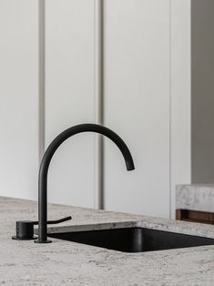 a black faucet sitting on top of a kitchen counter