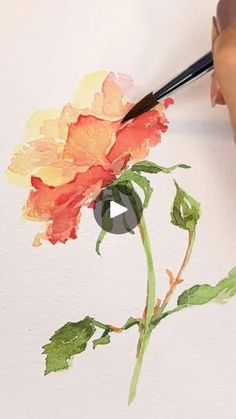 someone is painting a flower with watercolors