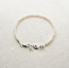 Bridesmaid Bracelet, Pearl Bracelet, Initial Bracelet, Personalized Jewelry, Bridesmaid Gift There are oodles of pearls on these bracelets. They make a lovely gift for your bridesmaids. One that they can wear well after your wedding day! + Small Freshwater Pearls (size of pearls are approx. 3mm) Sterling Silver Initial & Lobster Clasp. + Initial: Pick upon checkout. + Bracelet Length: Pick upon checkout. + Your jewelry will come in a jewelry box, tied with a ribbon, ready for gift giving. Th Adjustable Pearl Charm Bracelet For Bridesmaids, Adjustable Pearl Bracelet For Bridesmaids, Adjustable Beaded Bracelets With Pearl Drop For Bridesmaid, Pearl White Bracelets With Pearl Charm For Bridesmaids, Adjustable Pearl Bracelets For Bridesmaids, Adjustable Pearl Drop Bracelet For Bridesmaids, Pearl Charm Bracelet For Bridesmaid Gift, Pearl Charm Bracelet For Bridesmaids, Adjustable Pearl Charm Bracelet For Wedding