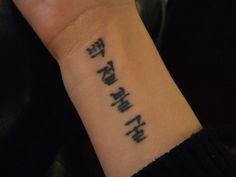 a person with a wrist tattoo that has the words in different languages on it,