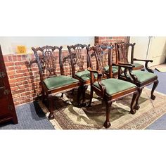 a set of four chairs sitting on top of a rug next to a brick wall