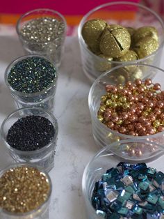 several bowls filled with different types of glitter