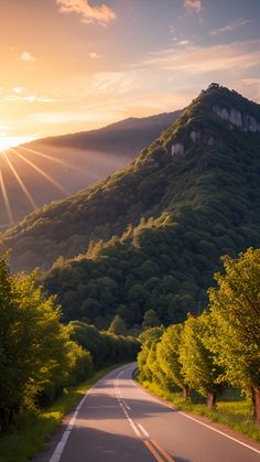 the sun shines brightly on a mountain road with trees lining both sides and mountains in the distance