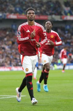 two soccer players are running on the field