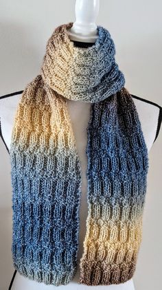 New Handmade Soft and Warm Knit Scarf in Blue, Brown, and Cream Variegated Fairyland Yarn - 6.5" x 65" This classic scarf is made of Fairyland yarn in variegated shades of Blue, Brown, and Cream. The colors are perfect for any gender. The style of this scarf works for a day of play or an evening by the fire. The pattern of this scarf is a staggered 2x2 ribbing to provide visual and textural interest without detracting from the beautiful flow of color changes. Size: 6.5" x 65" Contents: 60% Polyester, 20% Wool, 20% Cotton Care: Hand wash cold, lay flat to dry All of my products are produced in a smoke-free environment Shipping charges are for a single item. If multiple items are purchased at the same time, I will combine them and charge the least possible amount to ship them safely and in g Blue Knitted Yarn Scarves, Blue Knitted Yarn Scarf, Blue Crochet Knit Knitting Pattern, Blue Hand-knitted Yarn Patterns, Variegated Yarn, Knit Scarf, Shades Of Blue, Blue Brown, Scarf Wrap