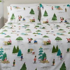 a bed with christmas themed sheets and pillows