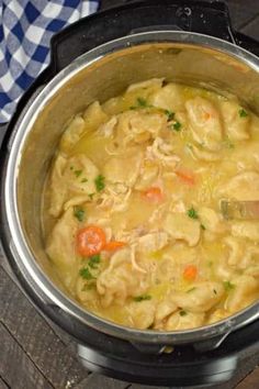 a pot filled with chicken noodle soup on top of a table