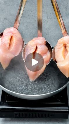 four pieces of raw chicken being cooked in a frying pan on a stove top