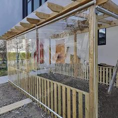 a wooden structure with glass on the top and bottom part covered in plastic sheeting