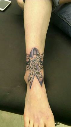 a person with a tattoo on their foot has a purple ribbon in the shape of a cross