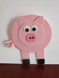 a pink pig cut out on top of a wooden table next to a white wall