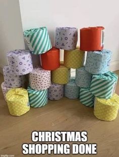 a pile of wrapped presents sitting on top of a wooden floor