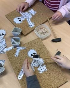 two children are making skeleton cut outs on cork