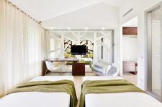 two beds in a room with white walls and green blankets on top of each bed