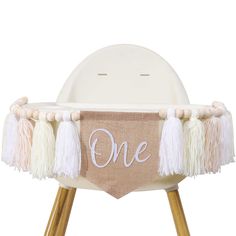 a white chair with some tassels on it and one sign hanging from the back