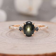 a black and white diamond ring sitting on top of a wooden slice with diamonds around it