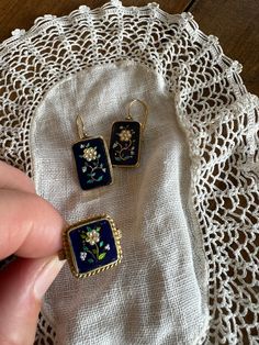 a pair of earrings sitting on top of a doily