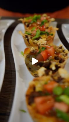 several small appetizers are lined up on white plates