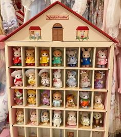 there is a doll house with lots of stuffed animals in the front and on the back