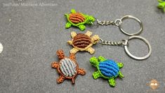 three crocheted turtle keychains are shown on a gray surface with green leaves