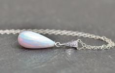 "A stunning new necklace modeled after my best selling earrings. The necklace features a lab created opal drop in white, with rainbow tones and flash throughout. The stone opal is 18mm tall (3/4\") and is secured to a paved CZ gemstone silver bail. Pendant hangs from sterling silver chain in your choice of length. Please choose desired chain length at checkout. Pendant measures 1 1/8\" long (30mm). ** Please see matching earrings here: https://www.etsy.com/listing/214222206/sale-rare-elegant-gen Elegant Drop Opal Jewelry, Elegant Hypoallergenic Opal Jewelry, Elegant Silver Pink Opal Necklaces, Elegant Silver Pink Opal Necklace, Handmade Elegant Pink Opal Jewelry, Elegant Handmade Pink Opal Jewelry, White Pink Opal Gemstone Jewelry, Elegant Pink Opal Jewelry For Formal Occasions, Elegant Formal Pink Opal Jewelry