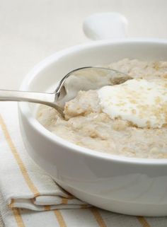 a white bowl filled with oatmeal on top of a striped table cloth