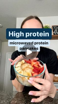 a man is holding a bowl of cereal with bananas and strawberries in it that reads high protein microwaved protein pancakes