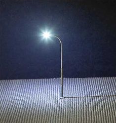 a street light sitting on top of a floor next to a wall with no lights