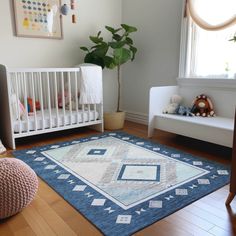 a baby's room with a blue rug and white crib