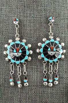 This Zuni Sunface set featuring turquoise, onyx, mother of pearl, coral, opalite and sterling silver inlay necklace, earrings, ring and bracelet was made by Zuni silversmith Abel Soseeah. The set is signed.Necklace: 18"Pendant Length: 2 5/8"Pendant Width: 1 3/4"Earrings:Length: 2 3/4"Width: 1 1/4"Bracelet:Size: 5 5/8" (will fit up to a 6 5/8" wrist)Gap: 1"Width: 1 5/8"Ring:Size 7.5Width: 1 1/4Length: 1 1/4Free shipping on all orders! We ship with USPS and always include tracking. All orders ship Artisan Blue Jewelry With Inlay, Sterling Silver Turquoise Inlay Jewelry, Turquoise Inlay Sterling Silver Jewelry, Sterling Silver Artisan Jewelry With Inlay, Artisan Sterling Silver Jewelry With Inlay, Artisan Sterling Silver Inlay Jewelry, Traditional Sterling Silver Jewelry With Natural Stones, Artisan Jewelry With Matching Earrings For Collectors, Artisan Collectible Jewelry With Matching Earrings