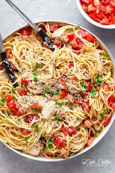 two bowls filled with pasta, tomatoes and parmesan cheese next to each other