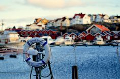 a boat is docked in the water with houses on the shore behind it and a life preserver