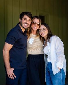 two women and a man are smiling for the camera while standing next to each other