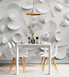 a white table with chairs and plates on it in front of a wallpapered background