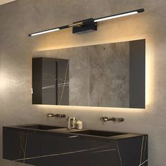 a bathroom vanity with two sinks under a mirror and lights on the wall above it