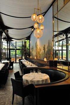 a restaurant with tables, chairs and chandeliers