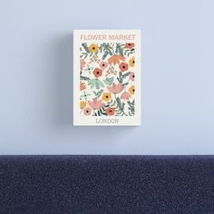 a flower market book sitting on top of a blue couch next to a white wall