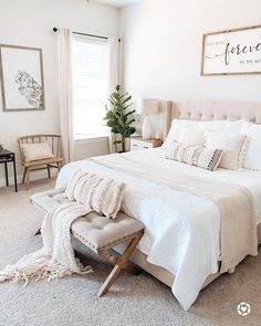 a bedroom with white bedding, pillows and blankets on the floor next to a window