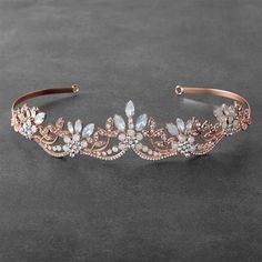 a gold headband with crystal stones and leaves on the side, sitting on a gray surface