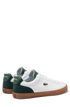 An embroidered crocodile and bold logos define a low-top sneaker made with a smooth leather upper that sits atop a grippy rubber sole. Lace-up vamp Leather and textile upper/textile lining/rubber sole Imported Green Leather Sneakers With Embossed Logo, Casual Green Sneakers With Embossed Logo, Casual Custom Sneakers With Embossed Logo, Casual Low-top Skate Shoes With Embossed Logo, Sneaker Men, Smooth Leather, Low Top, Nordstrom Rack, Top Sneakers