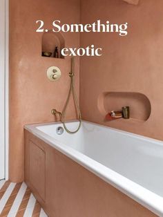 a bath tub sitting next to a toilet in a bathroom with the words 2 something exotic written on it