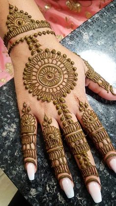 a woman's hand with henna tattoos on it