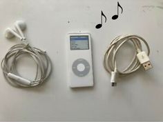 an ipod and ear buds are laying next to each other on a white surface with music notes in the background