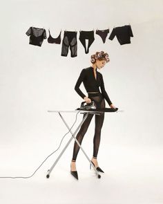 a woman ironing clothes with an electric iron in front of her on a white background